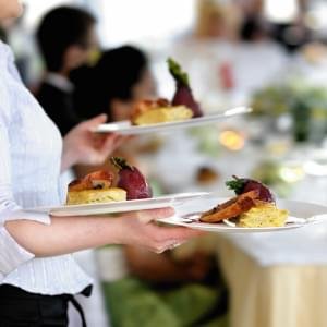 Server carrying plates of food.