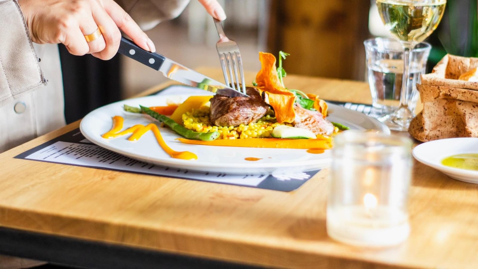 Steak, elegantly served, being cut.