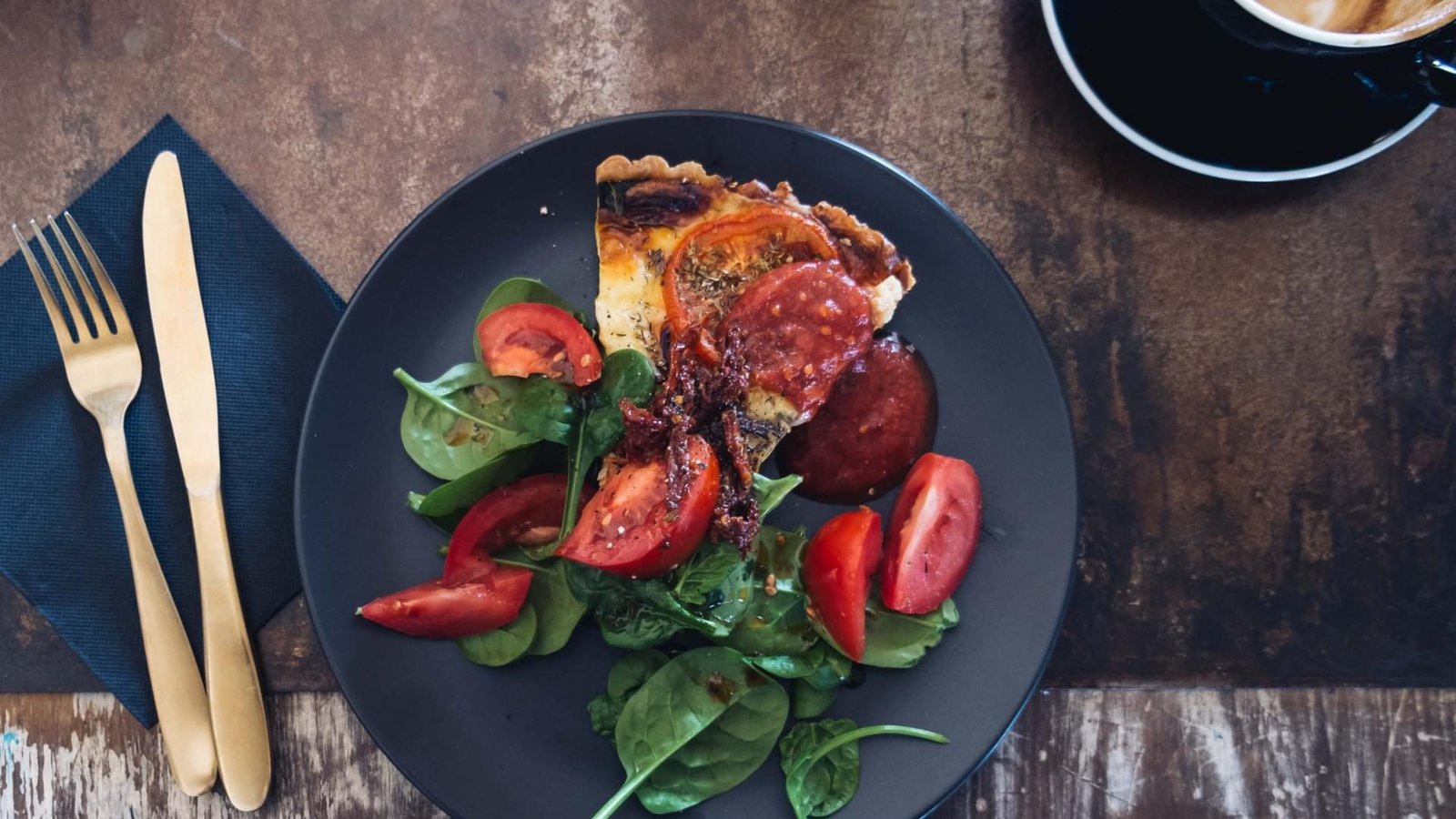 Pizza with fresh tomatoes and spinach leaves.