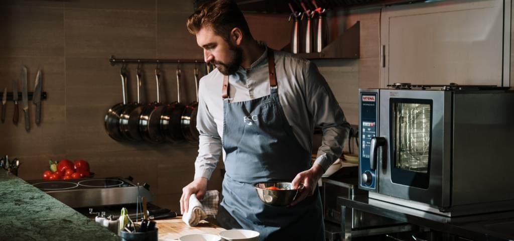 Chef (bearded male) working.